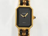 une montre noire et dorée, entourée d'une chaîne