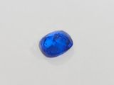 a blue sapphire stone on a white surface