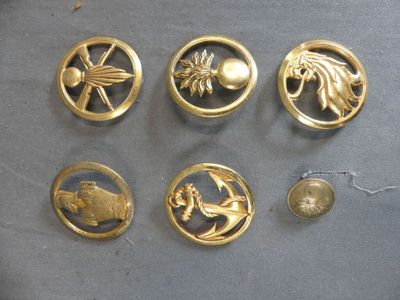 several gold metal buttons with various designs on them on a table