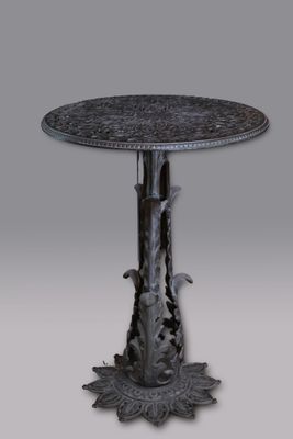 une image représentant une table ronde avec un piètement en métal et un motif floral