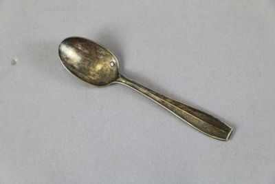 a silver spoon with a diamond on it sitting on a table