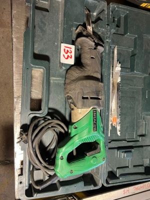 a green corded drill in a green case