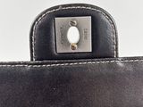 the back of a black leather purse with a silver metal clasp