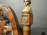 a statue of a woman holding a clock in front of a mirror