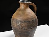a large brown vase with writing on it on a table
