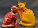 two figurines of a cat and a cat sitting next to each other