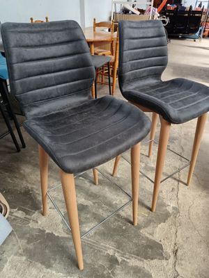 une paire de chaises grises à pieds en bois dans un entrepôt