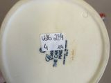 someone is holding a white vase with a black and white design