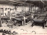 photographie en noir et blanc d'une usine où des ouvriers travaillent sur des machines