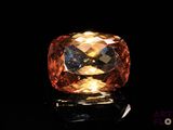 un gros plan d'un gros diamant orange sur une surface noire