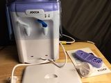 a water dispenser sitting on a table next to a laptop