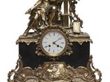 a gold clock with a statue on top of it