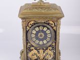 une horloge posée sur une table, sur fond blanc