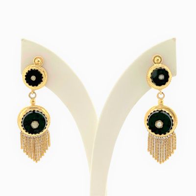 une paire de boucles d'oreilles noires et dorées ornées de pompons