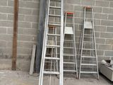 several ladders are lined up against a wall in a warehouse