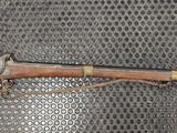 a rifle that is on display on a mesh surface