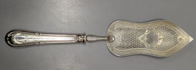 une cuillère en argent et un repose-cuillère posés sur une table
