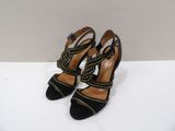 a pair of black and yellow high heels on a white surface