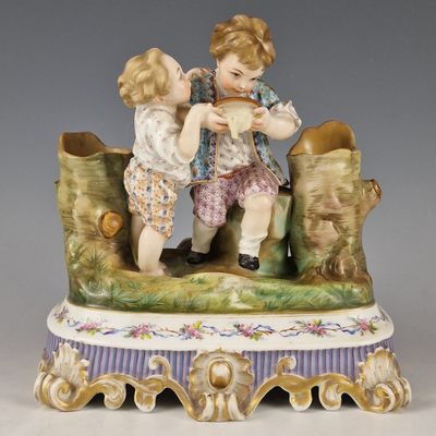 une figurine représentant deux enfants assis sur un banc