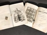 three books are open on a table with a black background