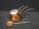 five pots and a spoon sitting on a black surface