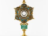 a close up of a gold and blue clock on a stand