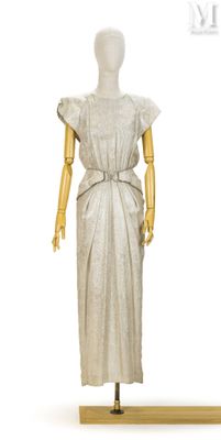 mannequin vêtu d'une robe blanche, posé sur un socle en bois