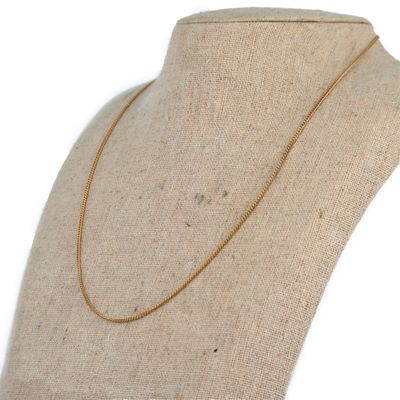 a gold necklace on a mannequin mannequin with a white background