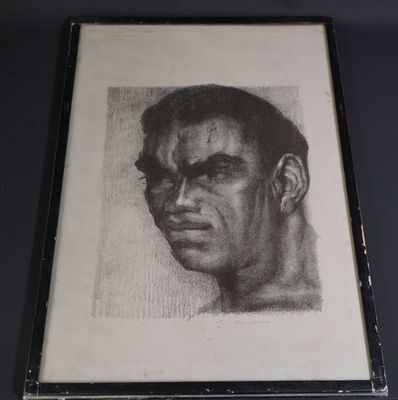 On voit une vieille photo représentant le visage d'un homme, encadrée dans un cadre noir.