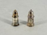 pair of silver salt and pepper shakers on a white surface