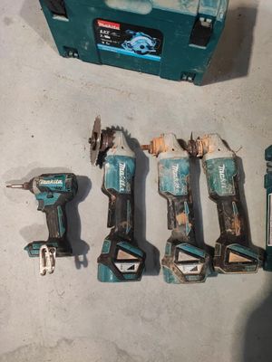 cinq outils posés par terre à côté d'une boîte à outils