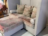 a woman standing next to a couch with a footstop