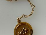 un gros plan sur un collier en or orné d'une abeille
