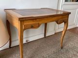 a small wooden table with a glass top and a lamp on it