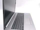 a silver laptop with a black keyboard on a white surface