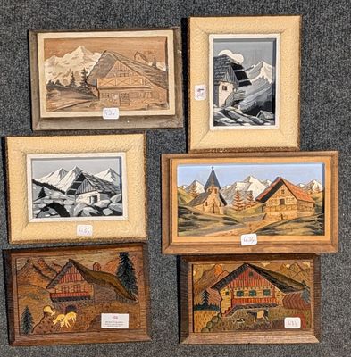 quatre photos encadrées représentant des montagnes et des maisons, exposées dans une pièce