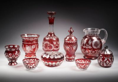 un ensemble de vases en verre rouge posés sur une surface blanche