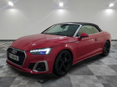 a red audi convertible parked on a checkered tile floor