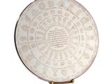une assiette blanche sur laquelle figure une inscription, posée sur une surface blanche