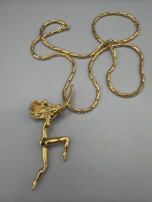 un collier plaqué or représentant une femme tenant une fleur