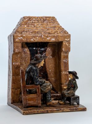 a figurine of a man and a woman sitting in front of a stone building