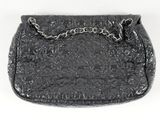 black purse with chain strap on white surface with white background