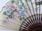 a close up of a fan with flowers and birds painted on it