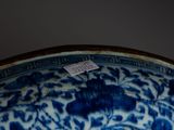 a close up of a blue and white plate with a tag on it