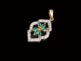 un pendentif en forme de fleur, composé d'une émeraude et de diamants, sur fond noir