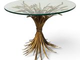 une table ronde en verre ornée de branches dorées