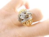 a woman ' s hand holding a gold and diamond ring