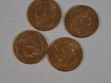 four coins sitting on top of each other on a white surface