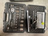 une trousse à outils dans un coffret posé par terre