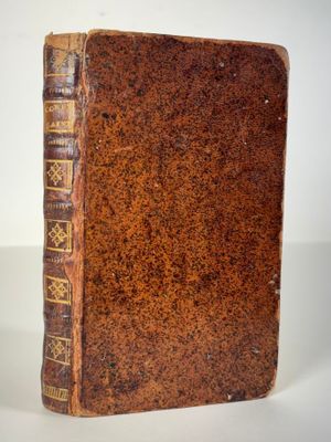 an old book sitting on top of a table next to a cup of coffee